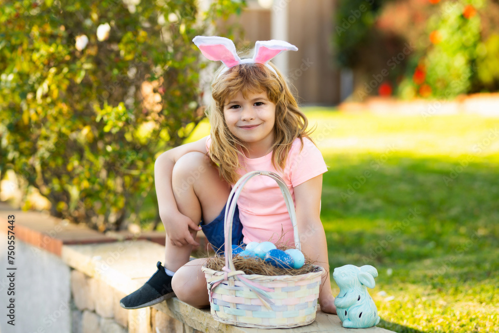 Fototapeta premium Happy Easter. Kids in bunny ears with Easter egg in basket. Boy play in hunting eggs. Spring holidays concept.