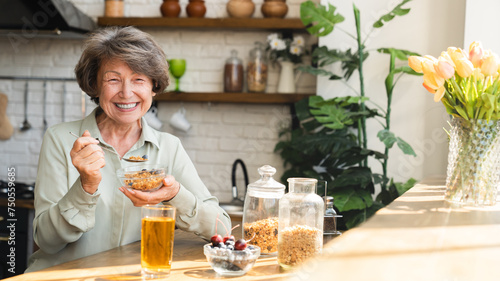 Healthy eating dietary habits concept. Caucasian senior old elderly woman grandmother eating breakfast  oats cereals with berries and apple juice