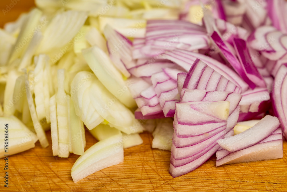 chopped red and yellow onions on a wooden board