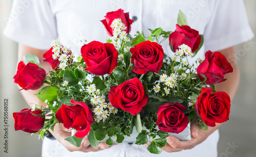 Fototapeta Naklejka Na Ścianę i Meble -  soft light tone with male hand giving bouquet of red roses