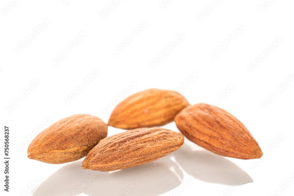 Several roasted almonds, macro, isolated on white background. Several roasted almonds, macro, isolated on white background.