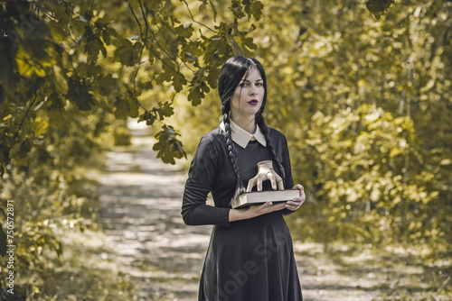 Young goth girl in black dress with white collar. Trend on a gothic style. Halloween look or masquerade photo