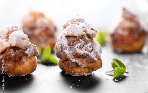 Profiterole or cream puff with filling,  powdered sugar topping with berries, isolated on white background, Fresh homemade Cream Puffs, cake, tasty French choux puff, ecler, dessert closeup. Pastries. © Subbotina Anna
