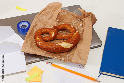 Office snack break with a large pretzel on a desk photo