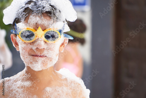Joyful boy covered in foam at party photo