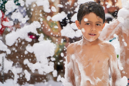 Joyful boy surrounded by foam at a party photo