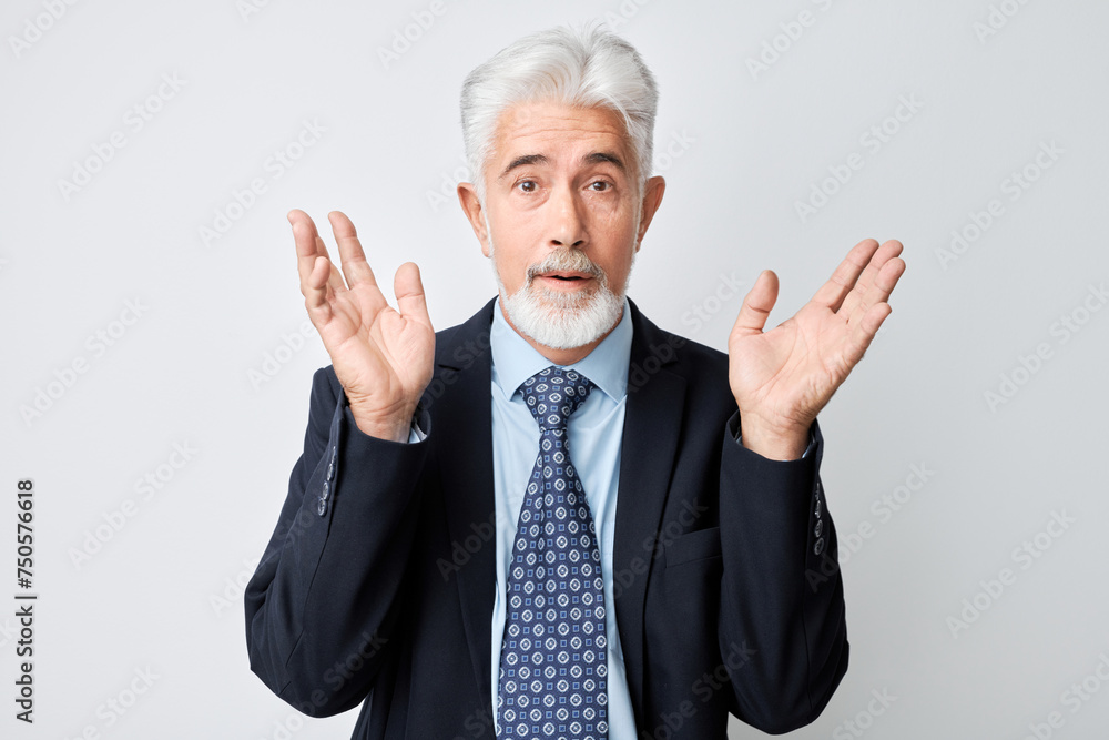 Senior businessman in suit with surprised expression, raising hands, isolated on white background. Senior businessman in suit with surprised expression, raising hands, isolated on white background.