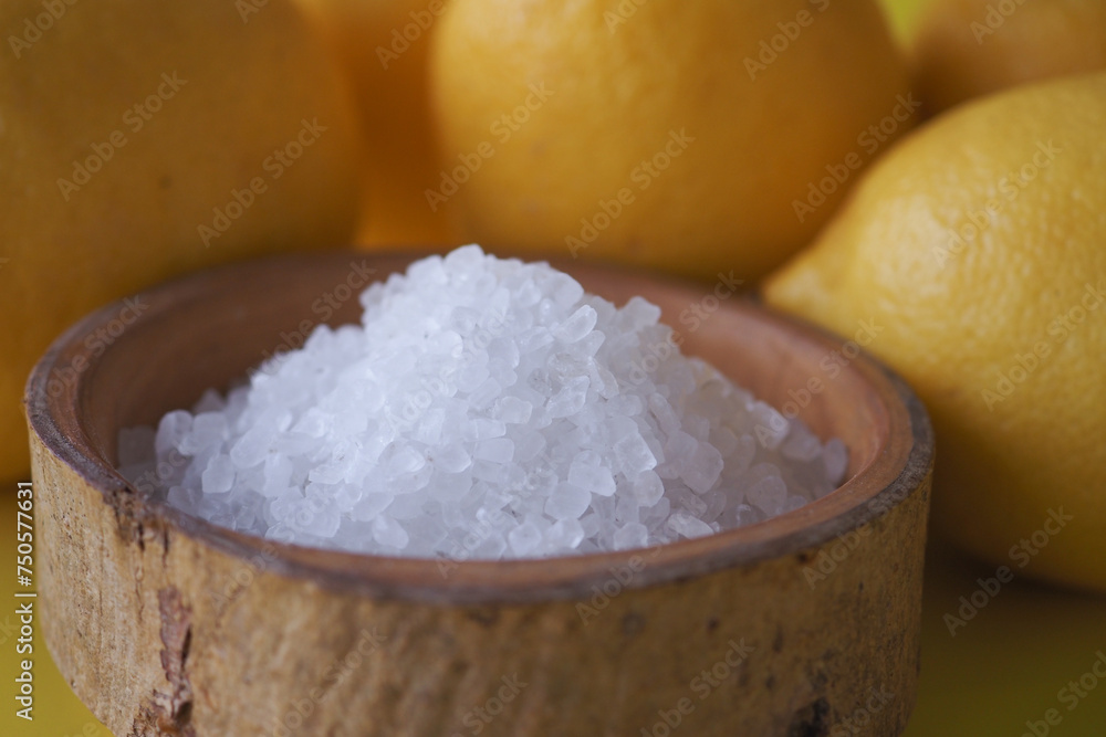 salt in a bowl and lemon on black yellow background salt in a bowl and lemon on black yellow background