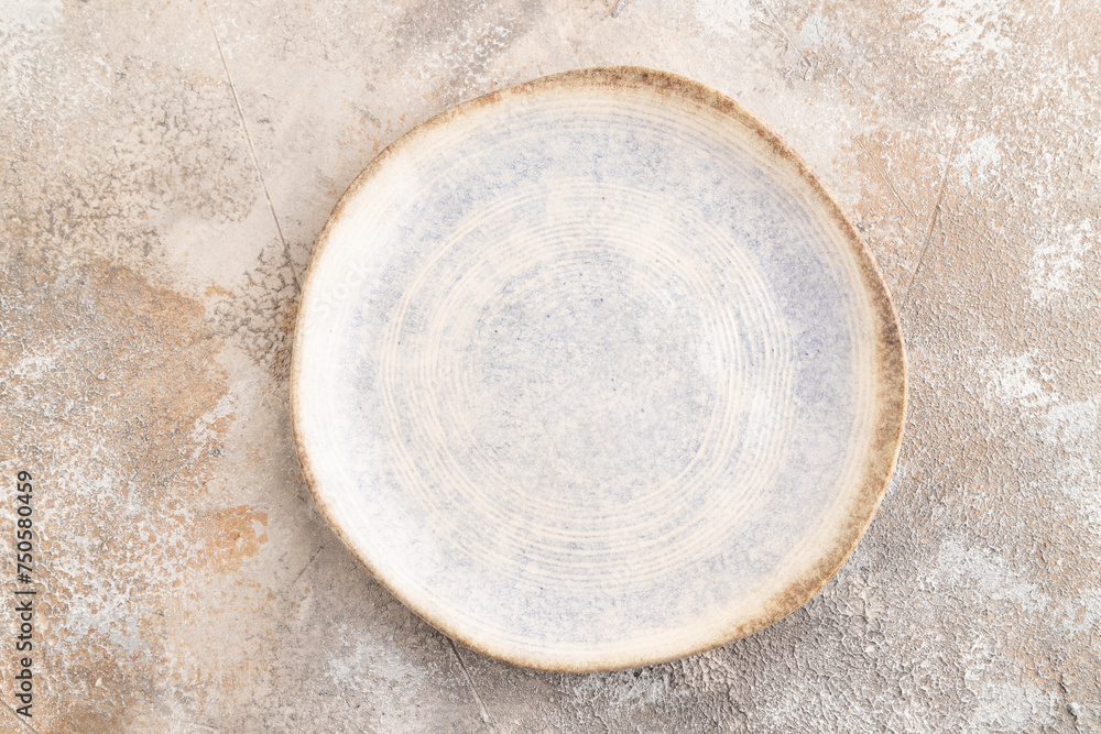 Empty blue and white ceramic plate on brown concrete background. Top view, copy space Empty blue and white ceramic plate on brown concrete background. Top view, copy space
