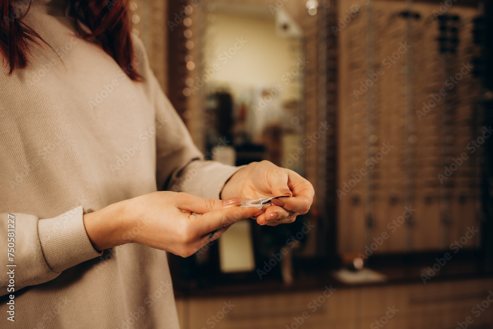 Obraz premium Woman opening a case containing a contact lens. Vision Correction and Health Care. Contact Lenses.
