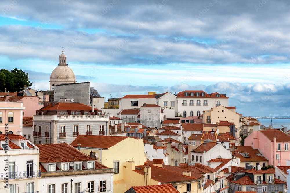Rooftops of and skyline of a Lisbon, Portugal neighborhood overlooking the Tagus River on a cloudy day