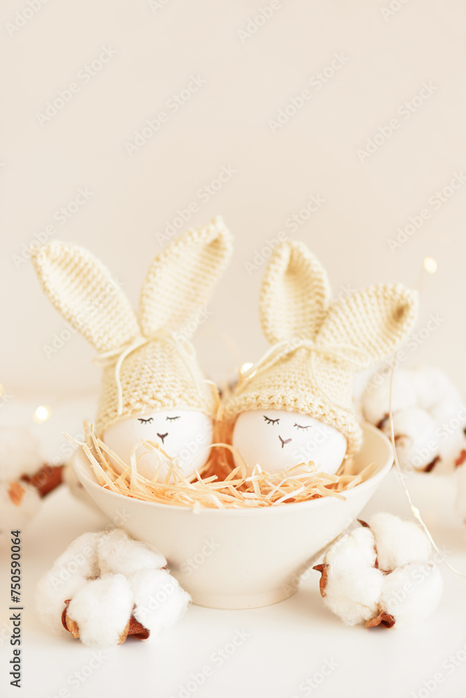 Easter eggs in crochet knitted hats with rabbit ears in nest. Easter celebration concept Easter eggs in crochet knitted hats with rabbit ears in nest. Easter celebration concept