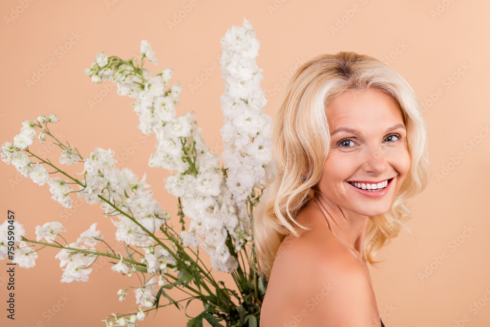 Photo of lovely cute retired woman enjoying natural fresh beauty product spring time isolated on beige color background Photo of lovely cute retired woman enjoying natural fresh beauty product spring time isolated on beige color background