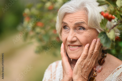 Portrait of happy senior woman posing at forest