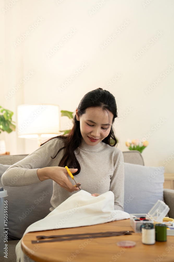 Woman repairs sews reuses fabric from old clothes economical reuse. DIY Hobby Reuse Recycling at home Woman repairs sews reuses fabric from old clothes economical reuse. DIY Hobby Reuse Recycling at home