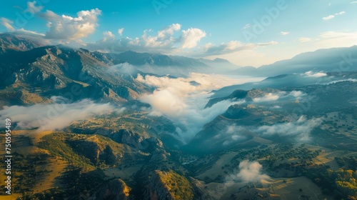 Majestic Mountain Landscape with Flowing Clouds and Sunrise over Tranquil Valley © pisan