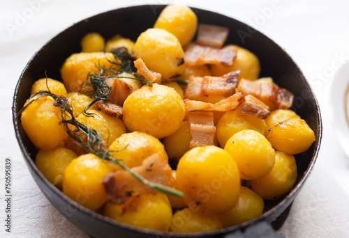 Delicious freshly cooked fried new potatoes with bacon served in a frying pan