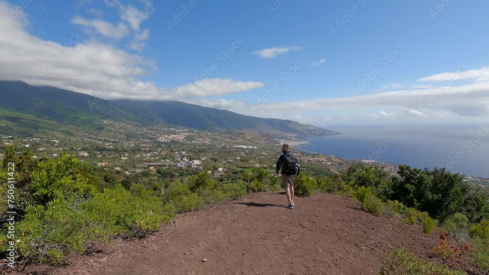 Man trekking along a path with sea views Man trekking along a path with sea views