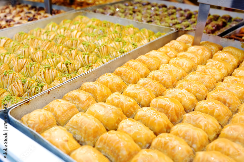 Assortment of traditional turkish dessert baklava on a showcase of shop. Sweets as a food background. Texture.