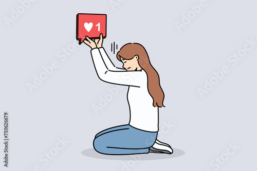 Woman blogger holds like icon, kneeling and dreaming of receiving lot of feedback from subscribers on social networks. Girl blogger suffering digital addiction needs constant approval followers