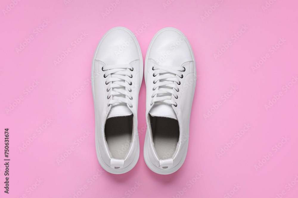 Pair of stylish white sneakers on pink background, top view Pair of stylish white sneakers on pink background, top view