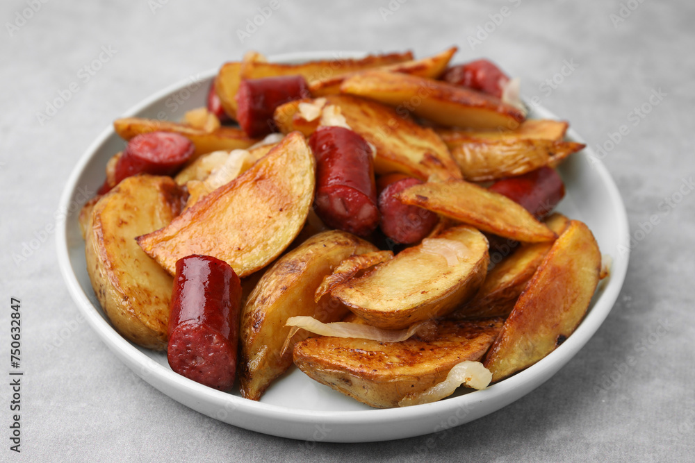 Delicious baked potato with thin dry smoked sausages and onion on gray table, closeup Delicious baked potato with thin dry smoked sausages and onion on gray table, closeup