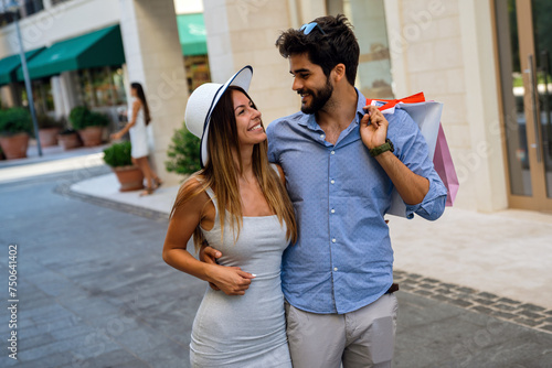 Beautiful young loving couple carrying shopping bags and enjoying travel, vacation together.