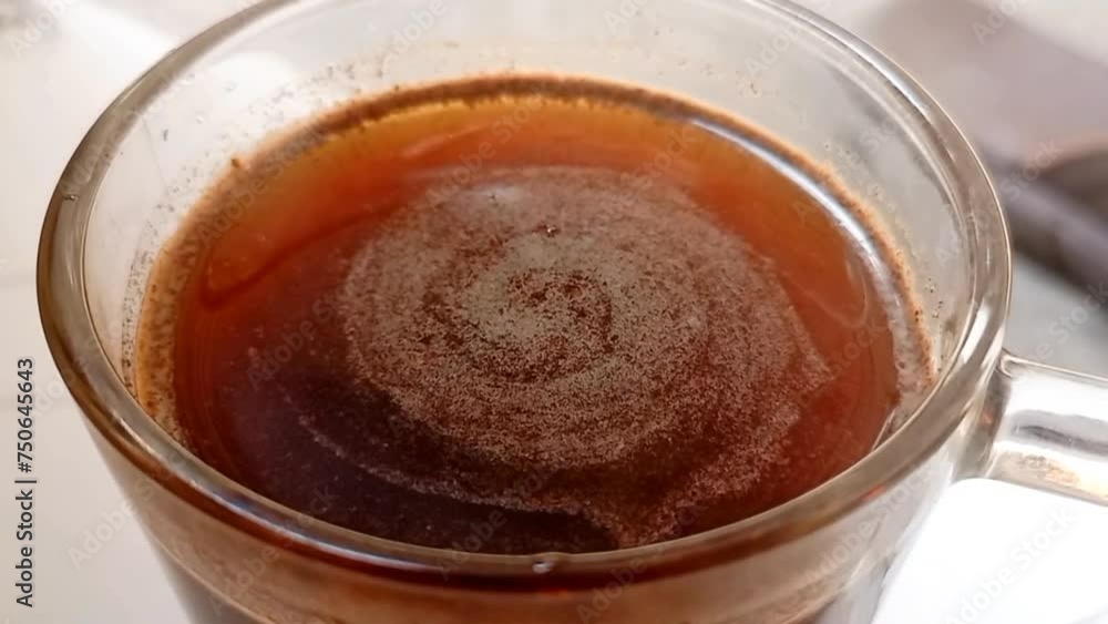 Black coffee with little ice spinning in the glass. top view shot video Black coffee with little ice spinning in the glass. top view shot video