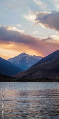 Scenic sunset over mountains reflecting in calm water with vibrant clouds at dusk in a tranquil landscape