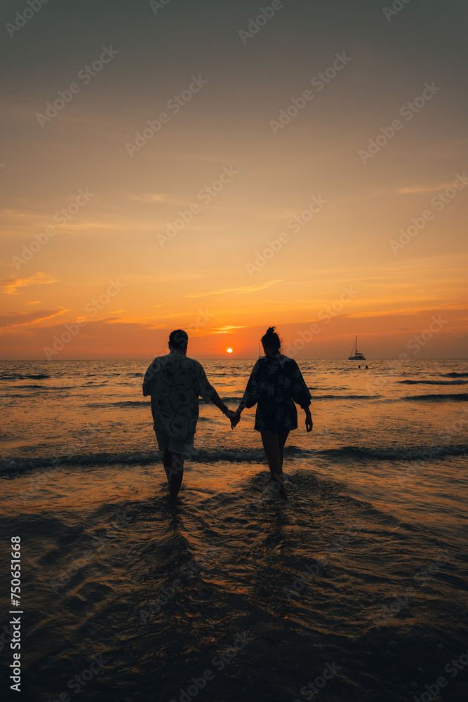 Summer sunset,Couple walking on the beach watching the sunset