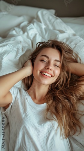 a beautiful and happy young american woman is relaxing in bed