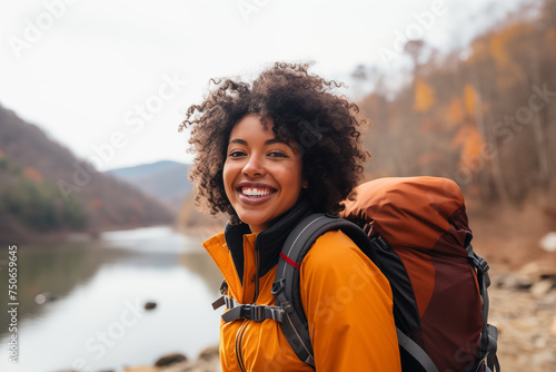 A portrait of a beautiful young African American woman relishing a mountain hike, displaying wanderlust and the thrill of mountaineering.