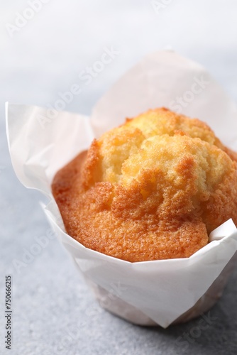 Delicious sweet muffin on grey textured table, closeup