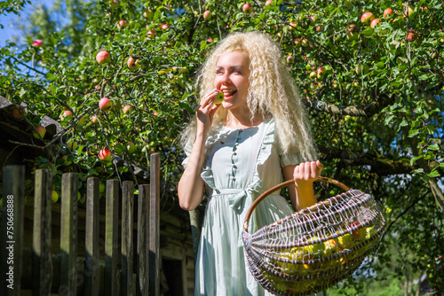 Beautiful blonde girl picking apples