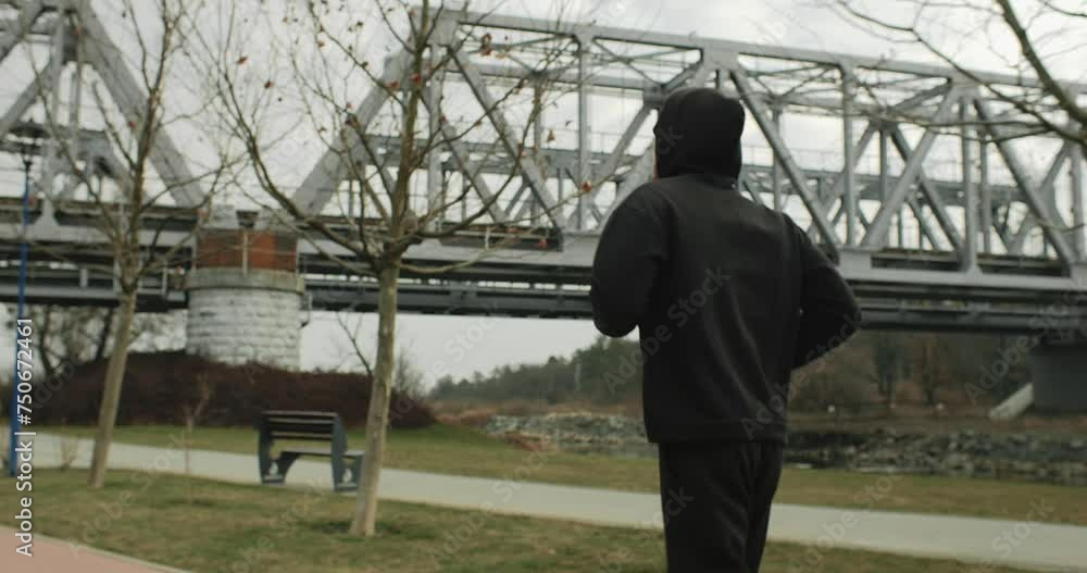 Motivation, medium shot of athlete man running outside in the park near the bridge. Healthy fit man jogging in the city Motivation, medium shot of athlete man running outside in the park near the bridge. Healthy fit man jogging in the city