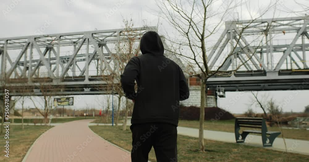 Motivation, medium shot of athlete man running outside in the park near the bridge. Healthy fit man jogging in the city Motivation, medium shot of athlete man running outside in the park near the bridge. Healthy fit man jogging in the city