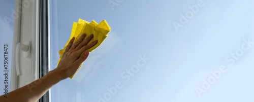 Foto Close up of woman hand cleaning the window with yellow rag, microfiber cloth