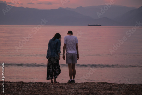 Thoughtful couple on a beach against the mountains