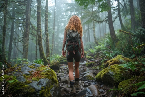 Solo Female Hiker Walking on Rocky Path in Misty Green Forest with Backpack, Adventure in Nature photo