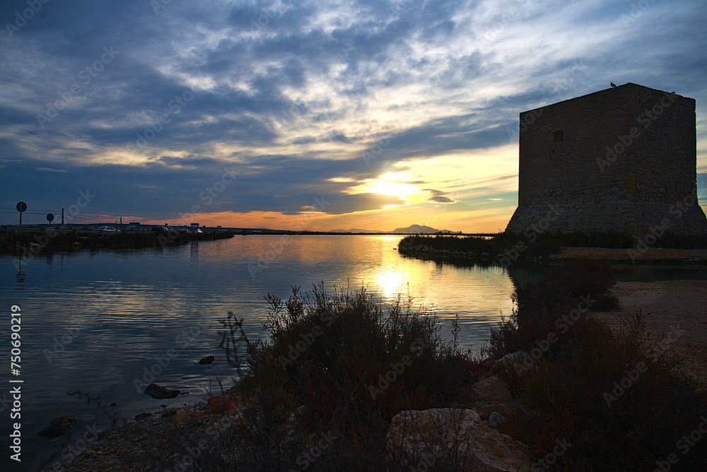Sunset over saline lakes with Tamarit watchtower near Santa Pola, Spain, Europe