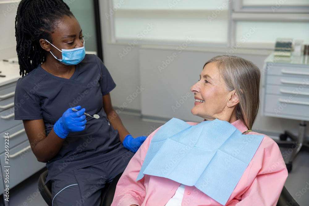 Woman patient sitting in dental chair at medical center while professional doctor fixing her teeth Woman patient sitting in dental chair at medical center while professional doctor fixing her teeth