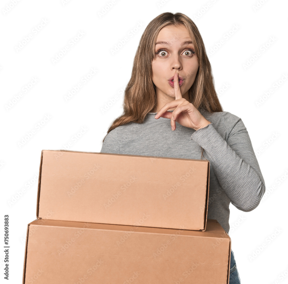Blonde woman with cardboard boxes moving on studio backdrop keeping a secret or asking for silence. Blonde woman with cardboard boxes moving on studio backdrop keeping a secret or asking for silence.