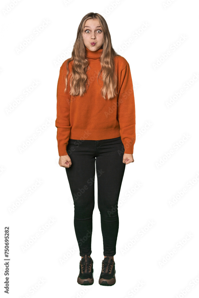 Studio portrait of a blonde Caucasian woman blows cheeks, has tired expression. Facial expression concept. Studio portrait of a blonde Caucasian woman blows cheeks, has tired expression. Facial expression concept.