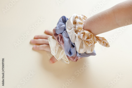 Lot of Colorful silk Scrunchies on baby hand. Hairdressing tools and accessories. Elastic HairBands, Bobble Sports Hairband for kids