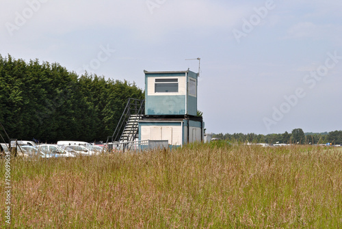 Mobile Industrial Buildings Stacked  beside Grassy Field on Sunny Day © eyepals