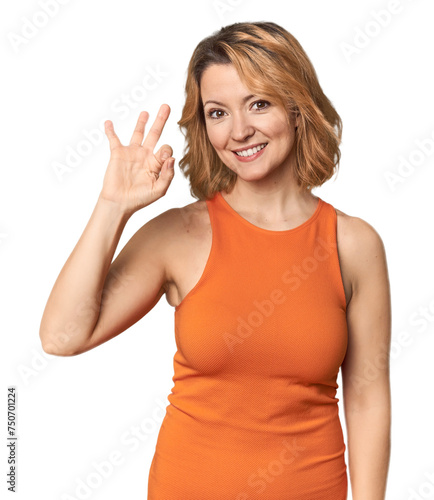 Blonde middle-aged Caucasian woman in studio cheerful and confident showing ok gesture.