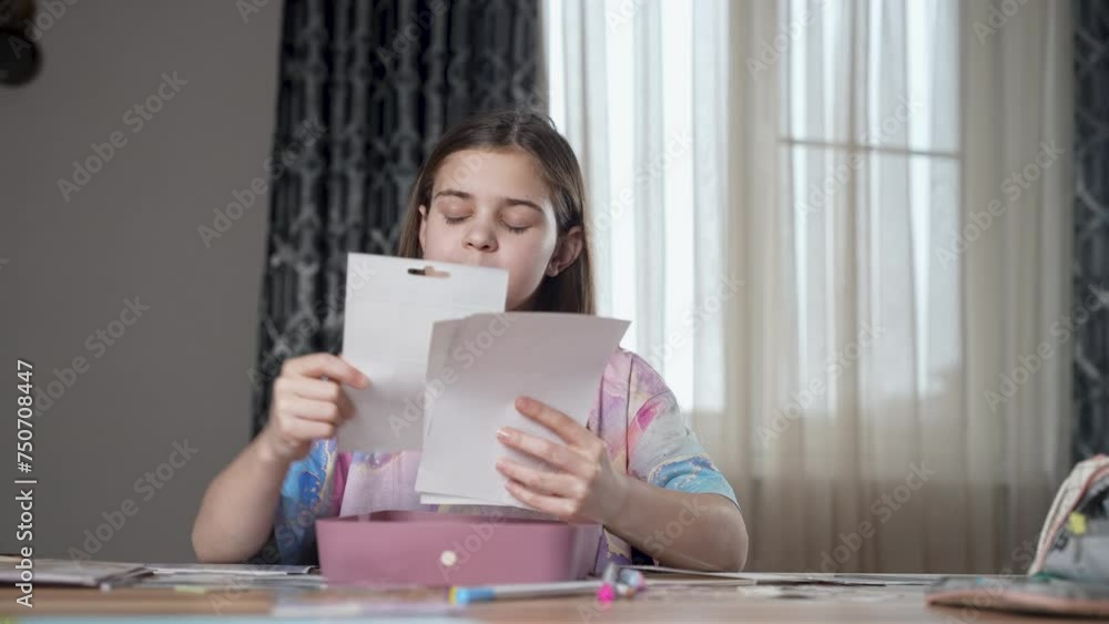 Cute girl sitting at table, thinking which sticker to choose to stick on. Child making surprise present card for holiday at home. Pretty smart kid studying alone. Сreative process, art class concept. Cute girl sitting at table, thinking which sticker to choose to stick on. Child making surprise present card for holiday at home. Pretty smart kid studying alone. Сreative process, art class concept.