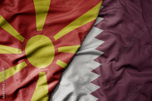 big waving national colorful flag of qatar and national flag of macedonia .