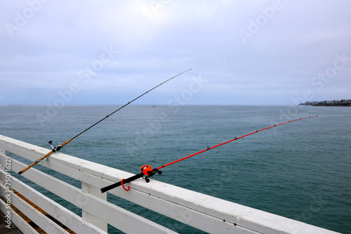 Black and red fishing rods set at historic Crystal Pier, San Diego, California