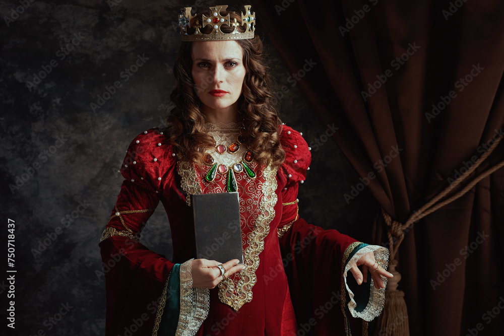 medieval queen in red dress with book and crown